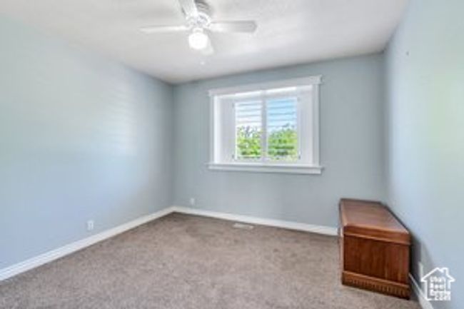 Carpeted empty room with ceiling fan and baseboards | Image 12