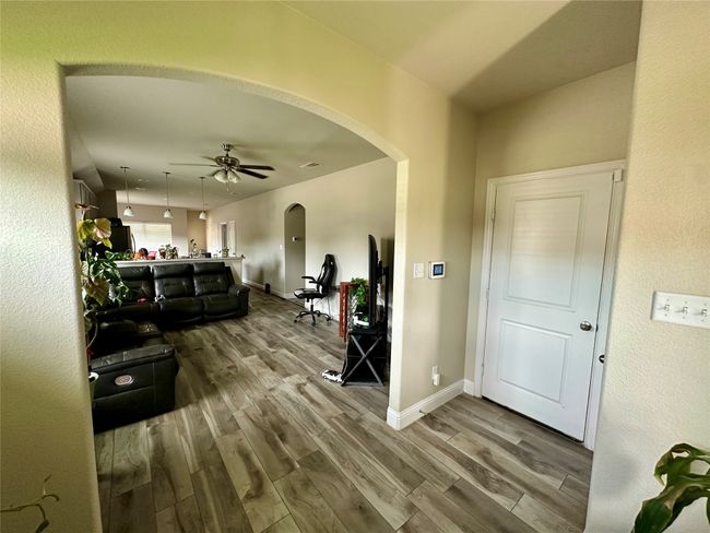 Living room featuring arched walkways, wood finished floors, and a ceiling fan | Image 8
