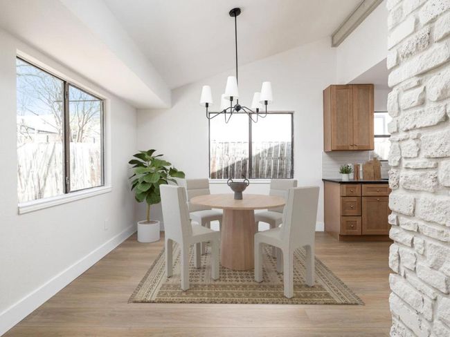 Dining space featuring an inviting chandelier, lofted ceiling, light wood-style flooring, and baseboards | Image 13