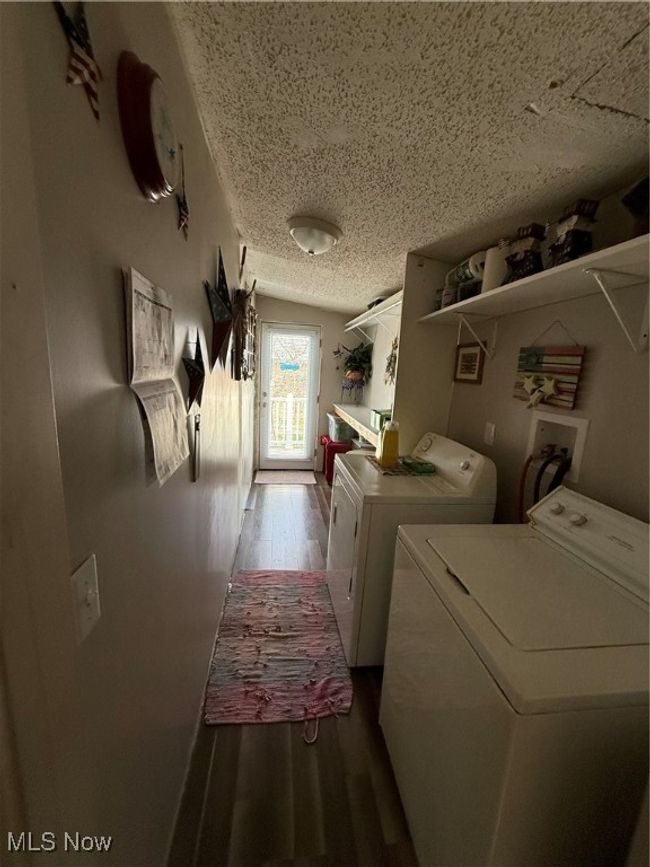 Clothes washing area with wood finished floors, a textured ceiling, laundry area, and washer and clothes dryer | Image 14