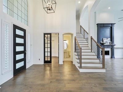 Foyer featuring dark hardwood / wood-style floors, a notable chandelier, and a towering ceiling | Image 3