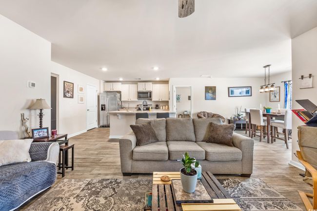 Living room featuring a ceiling fan, wood finished floors, and baseboards | Image 23