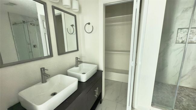 Full bathroom with marble finish flooring, a marble finish shower, a walk in closet, and double vanity | Image 19