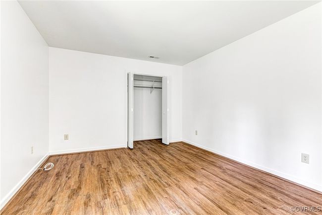Unfurnished bedroom with wood finished floors and a closet | Image 14