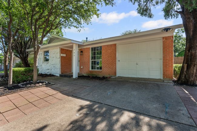 Single story home featuring driveway, a garage, and brick siding | Image 5