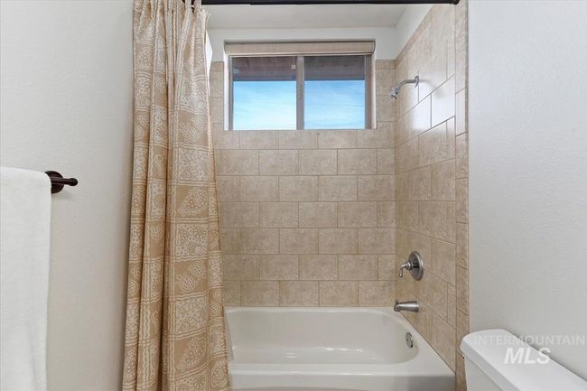 Bathroom with shower / bathtub combination with curtain and toilet | Image 42