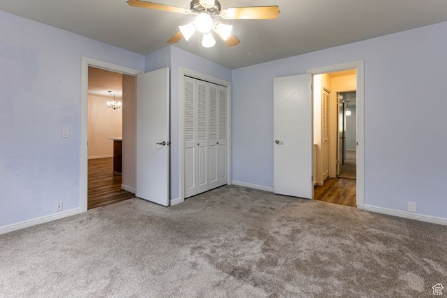 Unfurnished bedroom featuring carpet flooring, baseboards, a chandelier, and a closet | Image 17