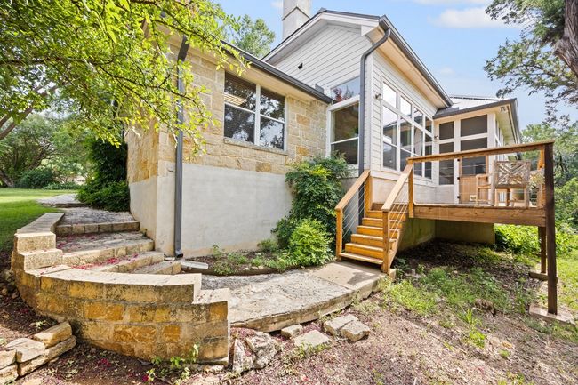 Steps from the deck take you down to a path that loops to the front yard. Storage space under the deck for yard tools. | Image 35