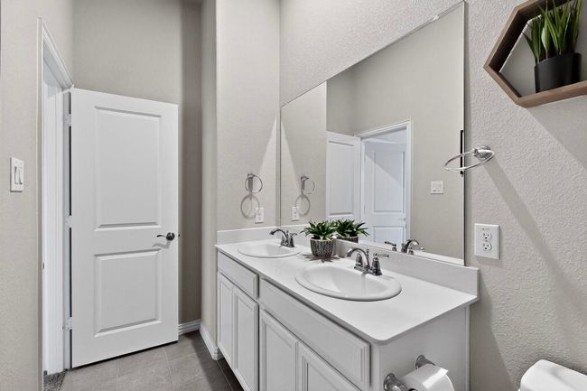 Bathroom with a textured wall, double vanity, and light tile patterned flooring | Image 32