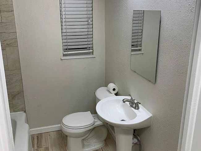 Bathroom with toilet, a bath, and wood finished floors | Image 7