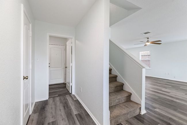 Stairway with Grey wood-style vinyl floors, ceiling fan, and baseboards | Image 17