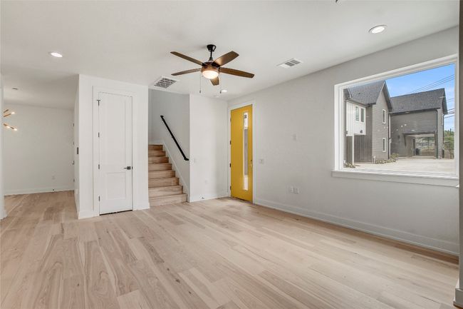 Unfurnished room with stairs, ceiling fan, baseboards, wood finished floors, and recessed lighting | Image 11
