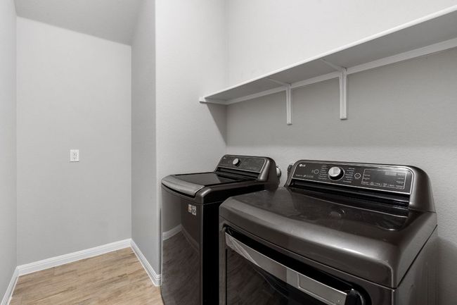 Spacious utility room with a designated space for a refrigerator and a washer and dryer that convey | Image 31