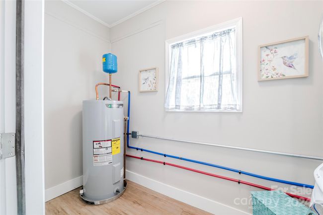 LVP was added to the laundry room. A newer water heater is featured here, as well as great storage options! | Image 37