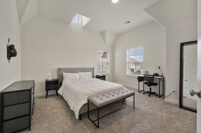 Bedroom featuring lofted ceiling, light carpet, baseboards, and a skylight | Image 14
