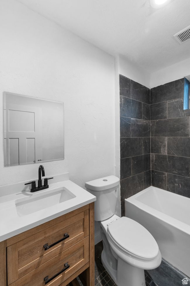 Bathroom featuring visible vents, toilet, shower / tub combination, and vanity | Image 13