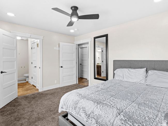 Carpeted bedroom featuring ensuite bath, baseboards, and a ceiling fan | Image 12