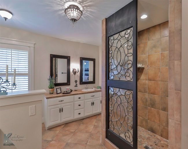 Bathroom featuring double vanity, a walk in shower, and tile patterned floors | Image 28