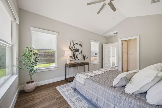 Bedroom featuring vaulted ceiling, multiple windows, wood finished floors, and ceiling fan | Image 20