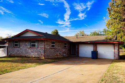 Single story home featuring a front yard and a garage | Image 1