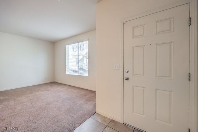 Entrance foyer with light colored carpet, baseboards, and light tile patterned floors | Image 11