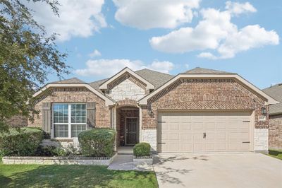 View of front facade featuring a front yard and a garage | Image 1