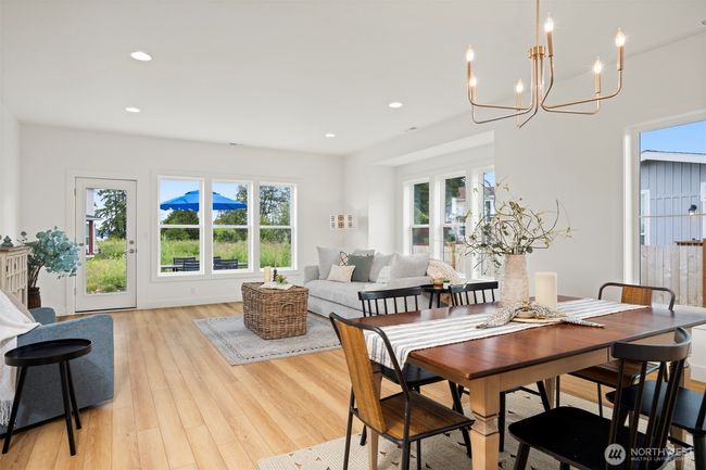 Another view across the dining area toward the living room with the water views beyond. | Image 7