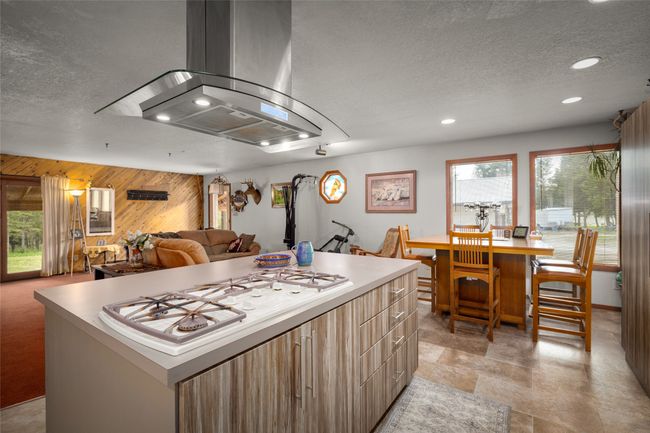 Kitchen featuring island exhaust hood, wooden walls, a textured ceiling, recessed lighting, and modern cabinets | Image 29