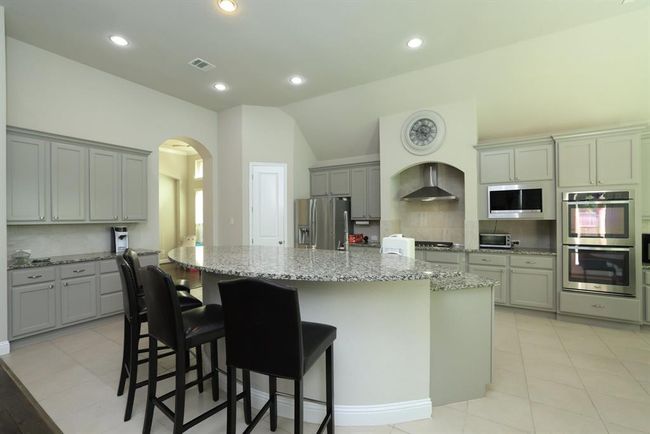 Stainless appliance and vent hood for exhaust. Cabinets are a soft gray with hardware. Side butler pantry. Double Ovens are convection and built in microwave | Image 21