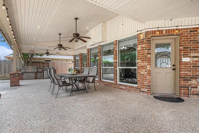 Step outside onto your expansive covered patio measuring approximately 32'x13' respectively, complete with area to sit under a breezy fan and enjoy a meal and cool beverage on a hot summer day or evening! | Image 37