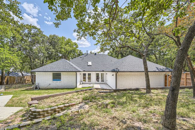 Back of house with a yard, brick siding, fence, a shingled roof, and french doors | Image 28
