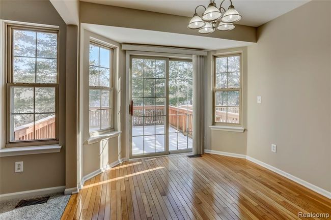 Open flow from the breakfast nook to the great room with hardwood floors and door leading to your private deck. | Image 6