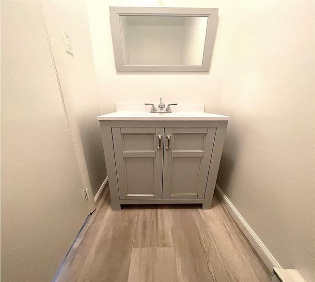 Bathroom with wood finished floors, vanity, and baseboards | Image 47