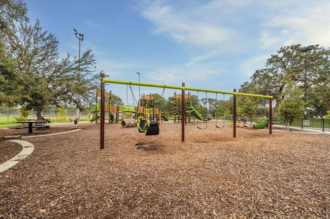 A close up look at TC Jester Park's play area; climbing towers to swing sets, it’s a kid’s dream—and a parent's favorite go-to for letting off steam. Big trees for shade, benches for breaks, and all the space your little adventurers needs. | Image 44