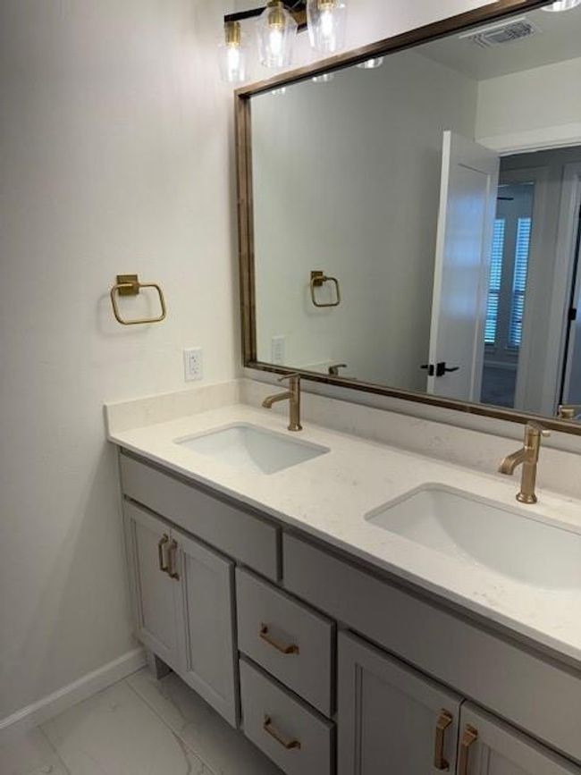 Bathroom featuring visible vents, marble finish floor, double vanity, and a sink | Image 33