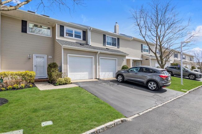Multi unit property with a front yard, an attached garage, driveway, and a chimney | Image 21
