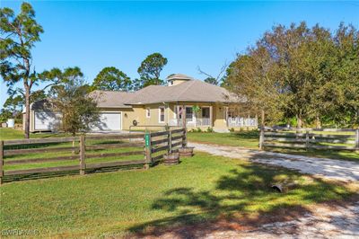 View of front of property featuring a garage, a front lawn, and a porch | Image 2