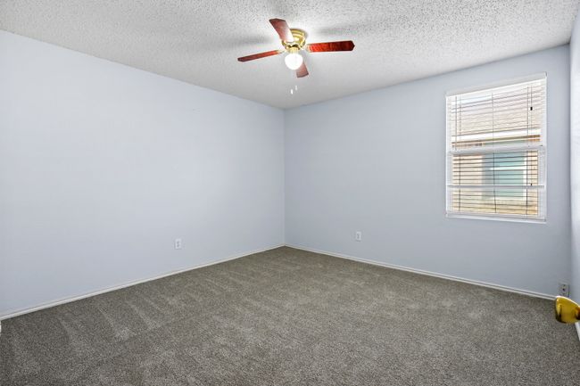 Carpeted spare room featuring a textured ceiling and ceiling fan | Image 15