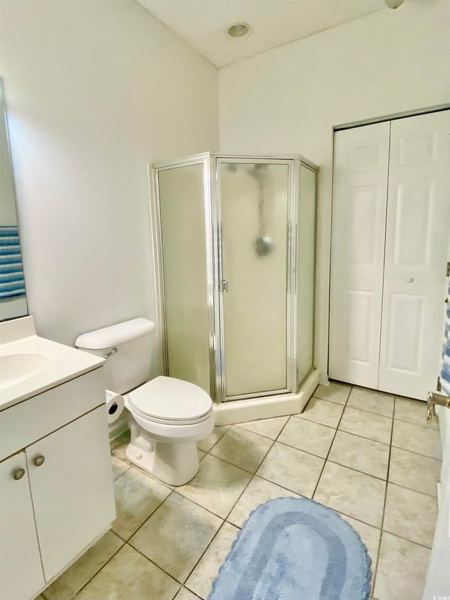 Bathroom featuring vanity, toilet, tile patterned floors, and a shower stall | Image 14