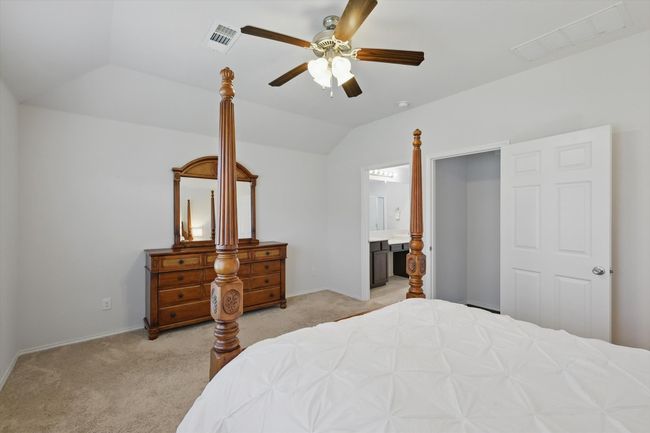 Bedroom featuring lofted ceiling, light carpet, ensuite bathroom, and visible vents | Image 29