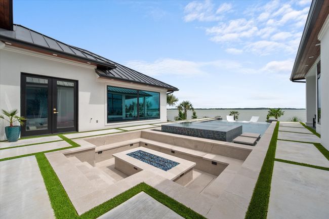 View of patio / terrace with a water view, an in ground hot tub, a fire pit, and french doors | Image 25