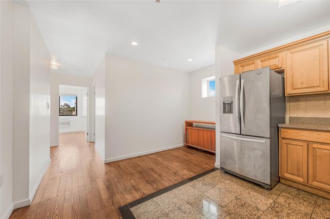 Kitchen featuring stainless steel fridge, recessed lighting, light wood-type flooring, and tasteful backsplash | Image 6