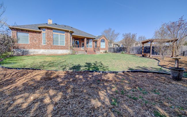 Rear view of property featuring brick siding, a lawn, a chimney, and a fenced backyard | Image 30