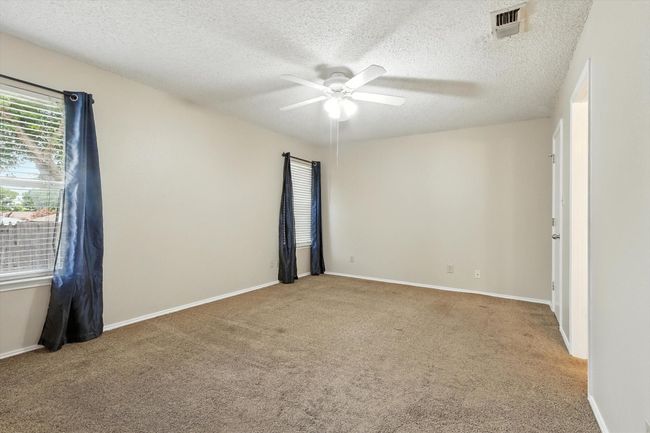 Unfurnished room featuring a ceiling fan, carpet floors, and a textured ceiling | Image 9