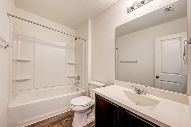 Bathroom featuring vanity, toilet, wood finished floors, washtub / shower combination, and a textured ceiling | Image 26