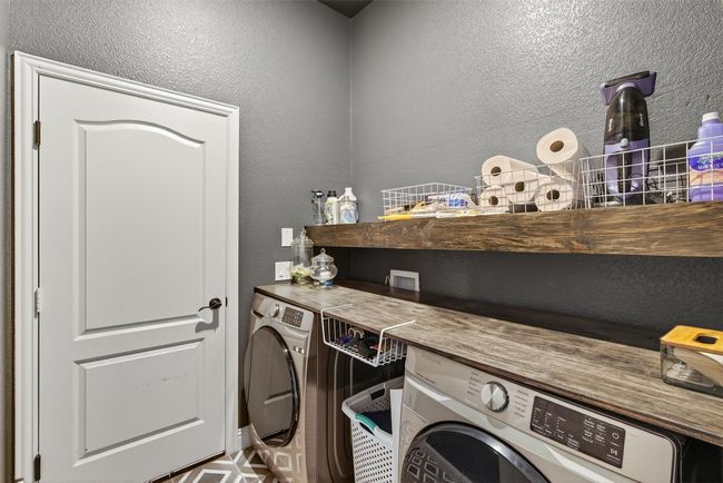 Laundry area featuring a textured wall and separate washer and dryer | Image 31