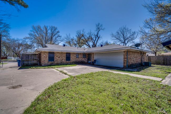 View of front facade featuring concrete driveway, brick siding, a garage, and a front lawn | Image 16