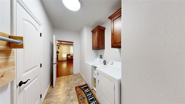 Clothes washing area with cabinet space, stone finish floor, baseboards, and washer and dryer | Image 29