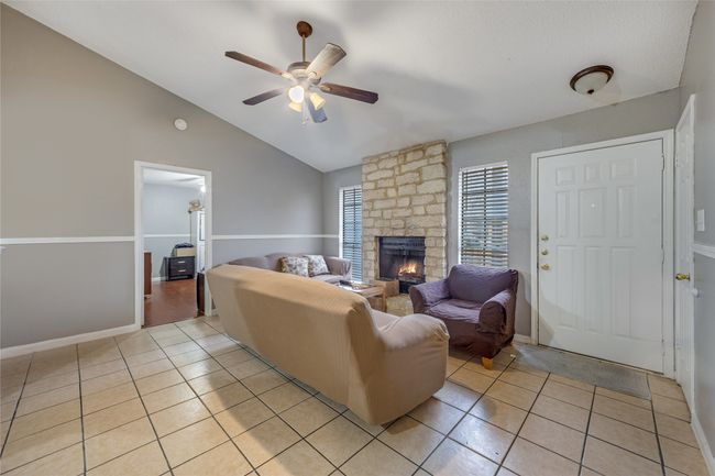 Unit B Living room with ceiling fan, a fireplace, vaulted ceiling, and light tile patterned flooring | Image 19