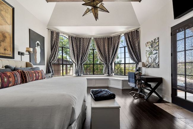 Bedroom featuring lofted ceiling, hardwood flooring, and multiple windows | Image 14